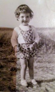 Über mich: Angela als kleines Kind am Strand von Juist.