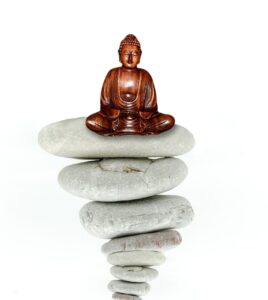 Buddha meditiert auf Steinen um seinen Wesenskern zu stabilisieren, sich zu zentrieren
